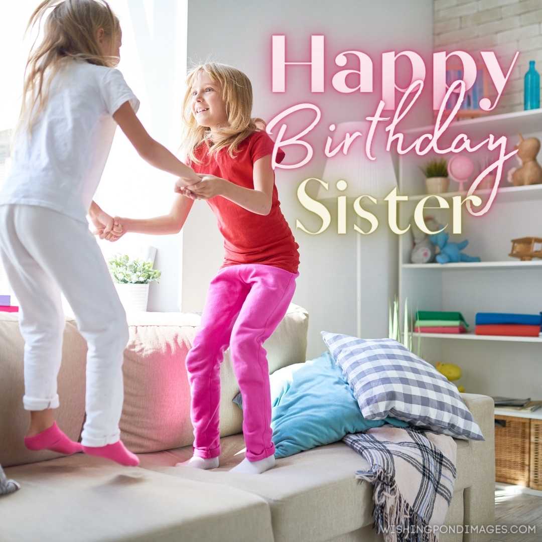 Cute fair-haired little sisters holding hands and jumping on a cozy sofa. Happy Birthday Sister Imag